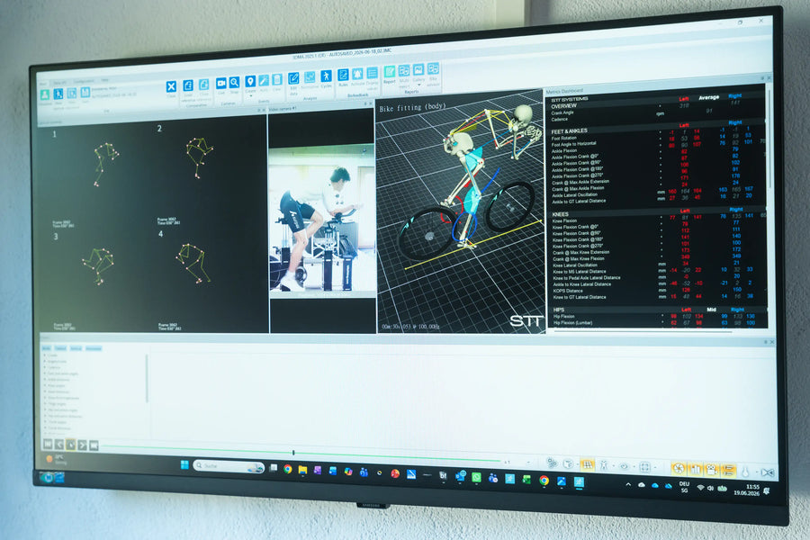 A large computer monitor displaying a software interface with a 3D bicycle motion analysis model, small video feeds, and data tables.